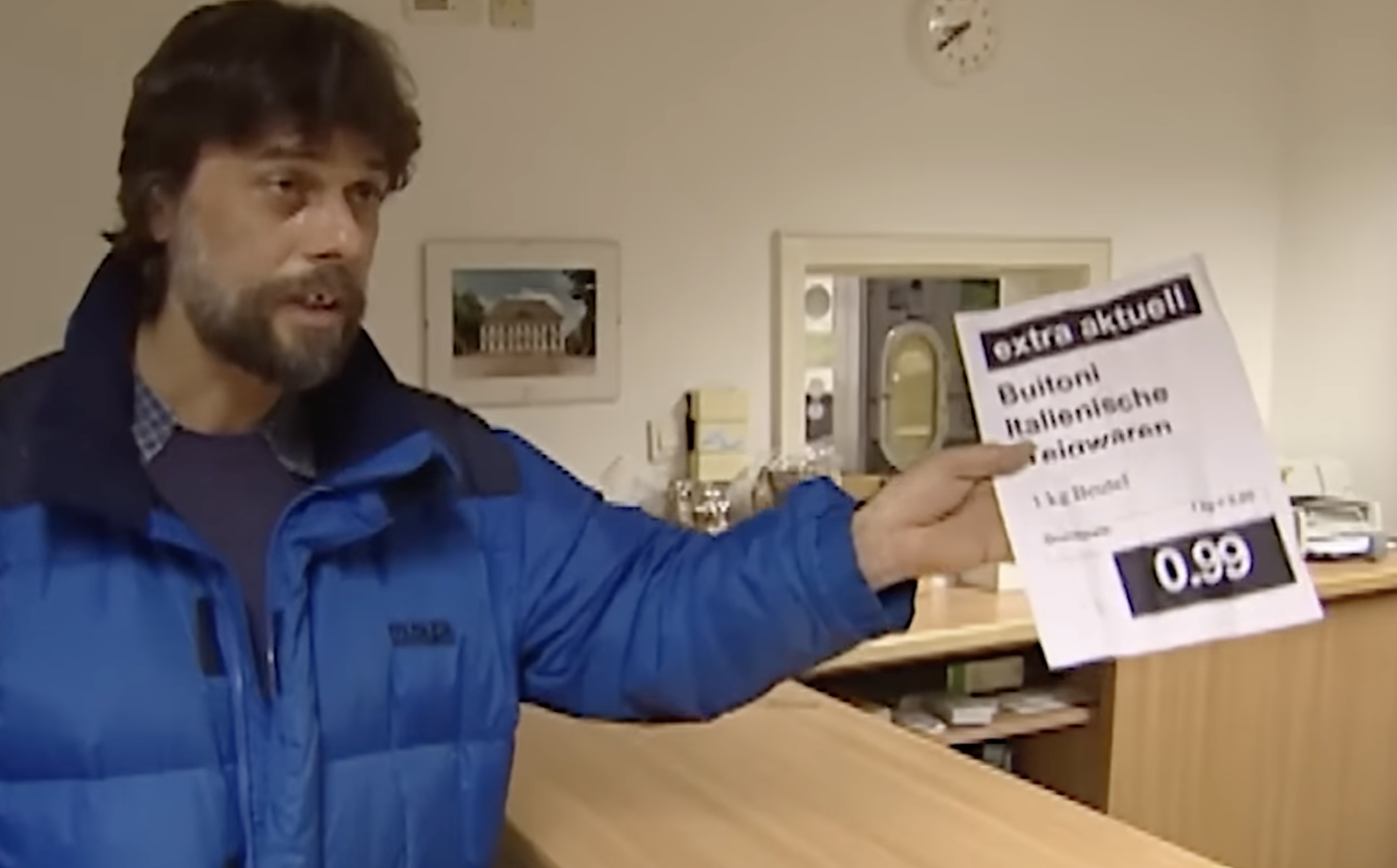 man holding a piece of paper that says buitoni italienische teigwaren 1kg Beutel Grundpreis 0.00 euro Preis 0.99 euro which translates to buitoni italian pasta 1 kilo bag price per kilo 0 euro Price 99 cents